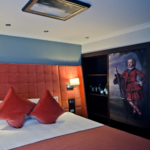 Privilege room, big comfy bed with orange headboard and painting mural on wardrobe door