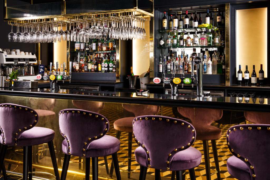 Bar area with purple bar stools and drinks for sale at Mercure Edinburgh City Princes Street Hotel.