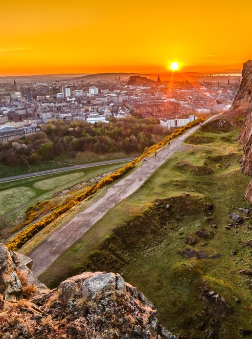 View of Edinburgh and Edinburgh castle from Arthur's Seat peak at sunset